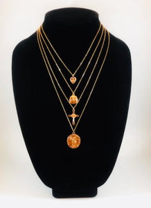 Set of four gold necklaces that can be layered or worn separately. Set includes Heart Charm with Rhinestone North Star Necklace, Compass Charm Necklace, Cross Charm Necklace, and Coin Charm Necklace.  Approximately 16-18-20-22" Length, with Clasp Closure with 3" Ball Extension.