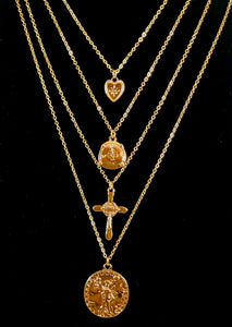 Magnified image of the set of four gold necklaces that can be layered or worn separately. Set includes Heart Charm with Rhinestone North Star Necklace, Compass Charm Necklace, Cross Charm Necklace, and Coin Charm Necklace.  Approximately 16-18-20-22" Length, with Clasp Closure with 3" Ball Extension.